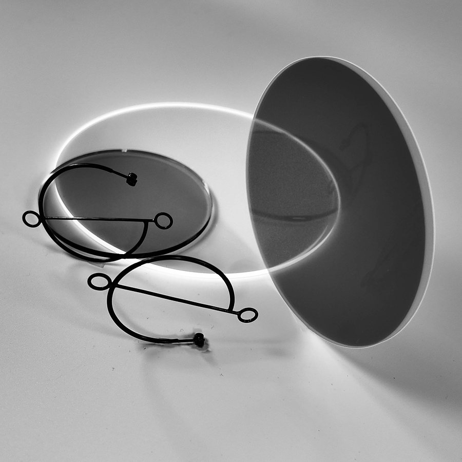 Black wire hoop earrings with open circles, beside acrylic discs