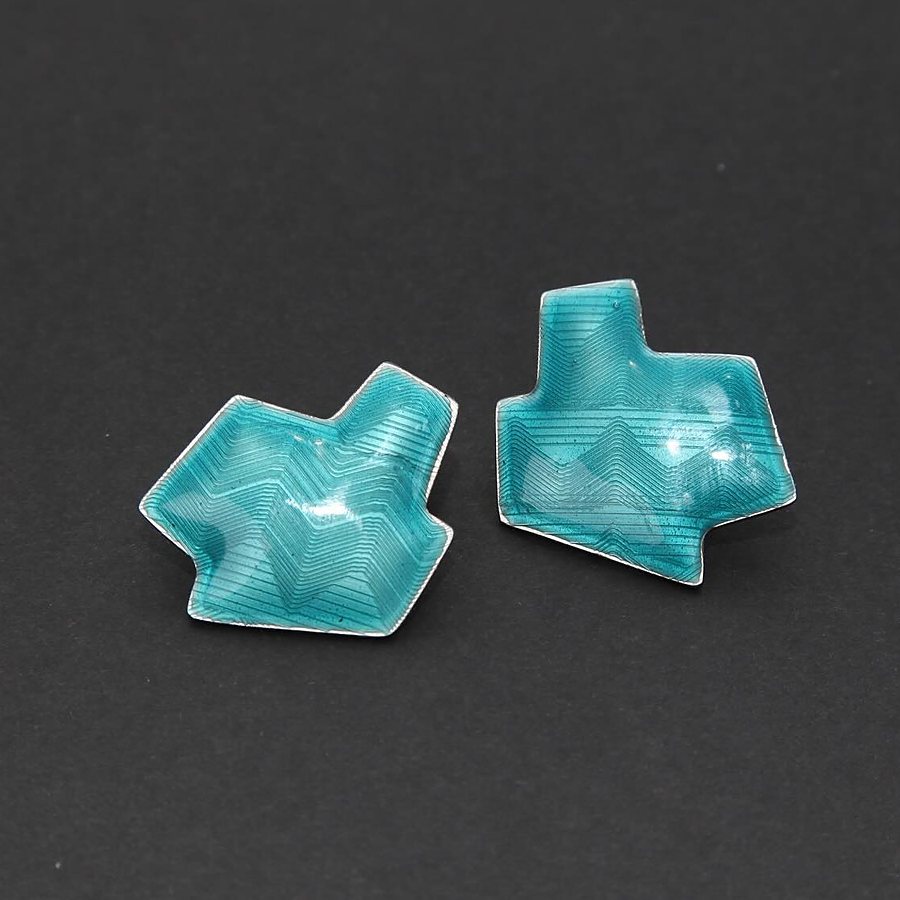 Angular petrol enamel stud earrings on a dark background